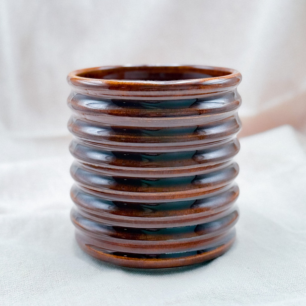 Ceramic tumbler with ribbed texture on a white background